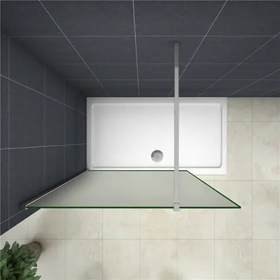 A top-down view of a shower enclosure with a white shower tray, a glass partition, and dark gray tiled walls.