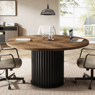 A round conference table with chairs in a modern office setting.
