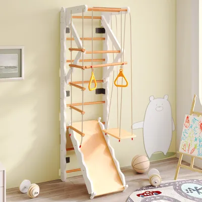 A children's indoor climbing frame with a slide and swing, set up in a room with a painted bear on the wall.