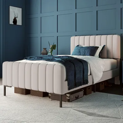 A bedroom scene with a bed, blanket, pillows, and wall art.