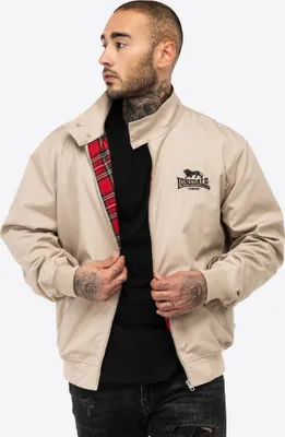 A man wearing a beige jacket with a red plaid lining.