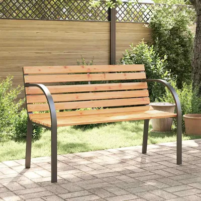 A wooden garden bench sits on a paved patio in a garden setting.