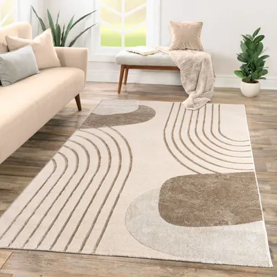 A modern living room with a sofa, rug, and bench.