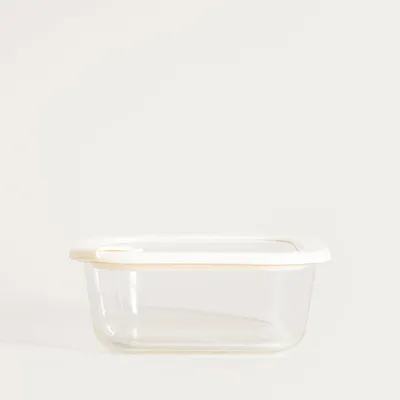 A clear glass food container with a white lid, presented against a plain white background.