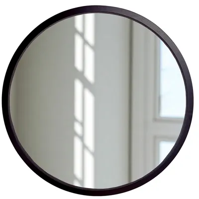 A round mirror with a black frame is shown against a white wall with light reflections.