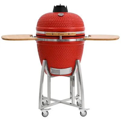 A red ceramic kamado grill on a silver stand with wooden side shelves, presented against a white background.