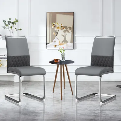 Two gray dining chairs are shown in a well-lit room with a small side table and a painting on the wall.