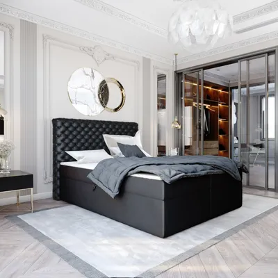 A luxurious bedroom with a black boxspring bed as the focal point, a walk-in closet visible in the background, and decorative wall art.
