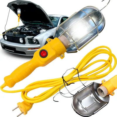 A work light with a yellow handle and cord is shown in front of a car with its hood open.