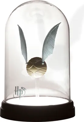 A Harry Potter Golden Snitch displayed under a glass dome on a black base.