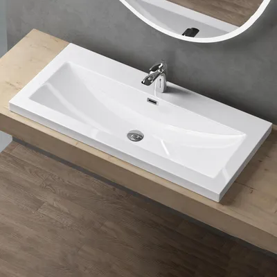 A modern bathroom sink with a chrome faucet, set on a wooden countertop.