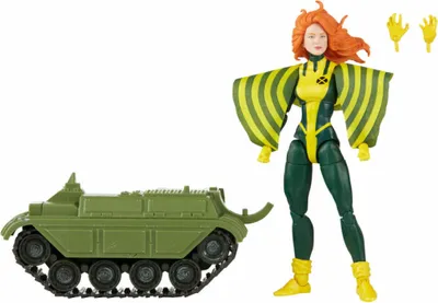 A toy action figure of a female character with red hair, wearing a green and yellow costume, standing next to a green toy tank. There are also two extra hands for the figure.