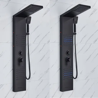 Two black shower panels mounted on a marble-tiled wall.