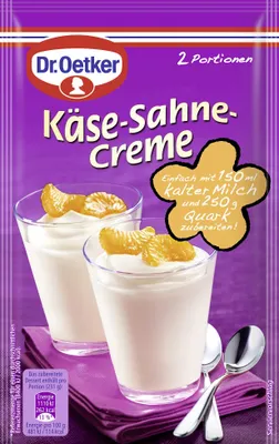 A package of Dr. Oetker Käse Sahne Creme dessert mix, with two glasses of prepared dessert shown.