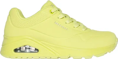 A side view of a single yellow sneaker.