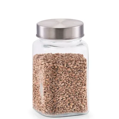 A clear studio shot of a glass storage jar filled with grains and topped with a stainless steel lid.