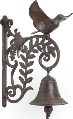 A cast iron door bell with a bird perched on top, mounted on a wall.