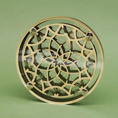 Frontalansicht eines kreisförmigen Holz-Acryl-Labyrinths mit sternförmigem Blütenornament und vier Schraubköpfen.