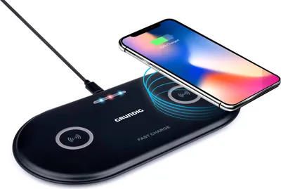 A black dual wireless charging pad with a smartphone on top, charging.