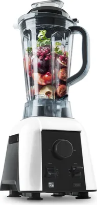 A white and black blender filled with fruits and vegetables, set against a white background.
