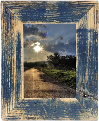 A rustic wooden picture frame with a landscape scene inside.