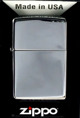 A Zippo lighter is displayed in its packaging against a black background.