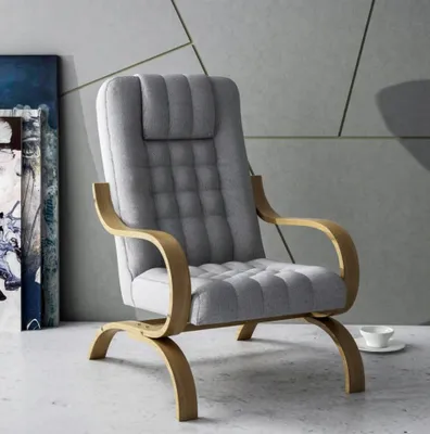 A grey armchair with wooden armrests and legs, placed on a light grey floor against a grey wall with geometric patterns.