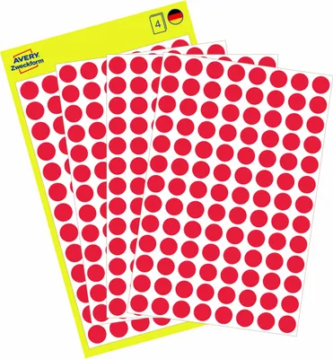 A stack of sheets of red circular stickers on a yellow backing sheet.