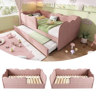 A pink upholstered bed with a pull-out trundle bed, set in a child's bedroom with a rug and toys.