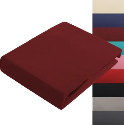 A folded burgundy bedsheet is shown on a white background, with a stack of different colored fabric swatches to the right.