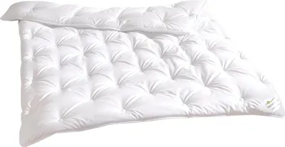 A white duvet or comforter is shown folded and lying on a white surface.