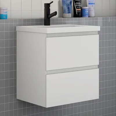 A white bathroom vanity with two drawers is shown against a tiled wall.