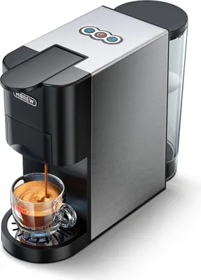 A close-up of a silver and black espresso machine brewing coffee into a clear glass mug.