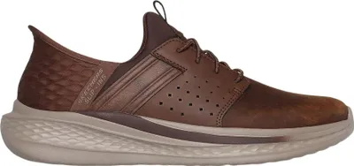 A side view of a brown SKECHERS SLIP-INS SLADE - ZACHARY shoe against a white background.