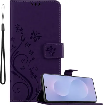 A purple flip phone case with a floral and butterfly design is shown open, with a smartphone placed inside. A wrist strap is attached to the case.