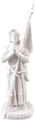 A white statue of Joan of Arc holding a flag.