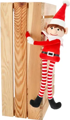 A plush elf figure is leaning against a wooden crate.