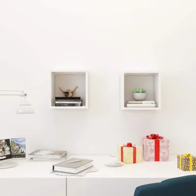 A white desk with two white cube shelves mounted on a white wall.