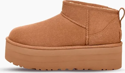 A side view of a single brown UGG boot with a platform sole.