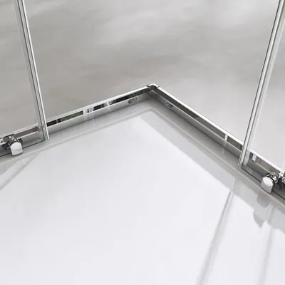 A close-up view of the corner of a shower enclosure, showing the metal frame and glass panels.