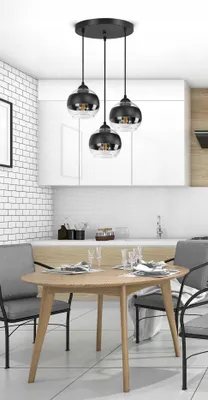 A modern dining room with a pendant light fixture hanging over a wooden table and chairs.