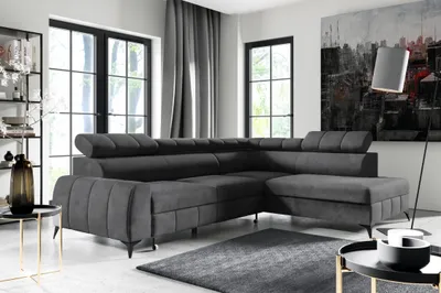 A modern living room with a large sectional sofa, a floor lamp, and artwork on the wall.