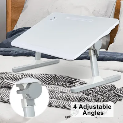 A white laptop table is set up on a bed with a blanket.