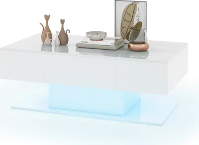 A white high-gloss coffee table with LED lighting underneath, decorated with vases, books, and a decorative bowl.
