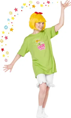 A woman in a green t-shirt and white shorts, wearing a yellow wig with a red bow, poses with her arms outstretched. Colorful stars are scattered around her.