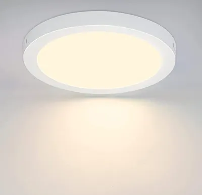 A white, round LED ceiling light is mounted on a light gray ceiling.