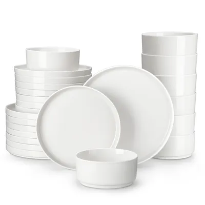A collection of white ceramic plates and bowls stacked and arranged on a white background.