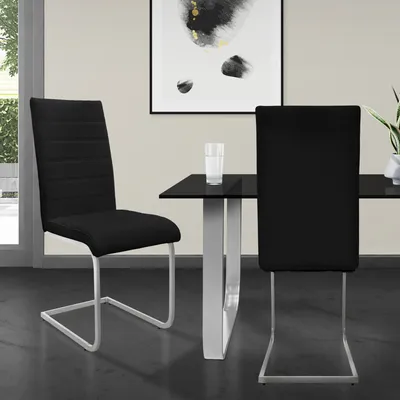 Two black dining chairs are shown in a dining room setting with a glass-top table.