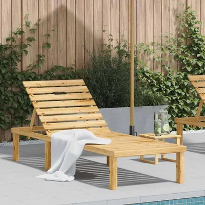 A wooden sun lounger is placed on a patio next to a swimming pool, with a wooden fence and greenery in the background.