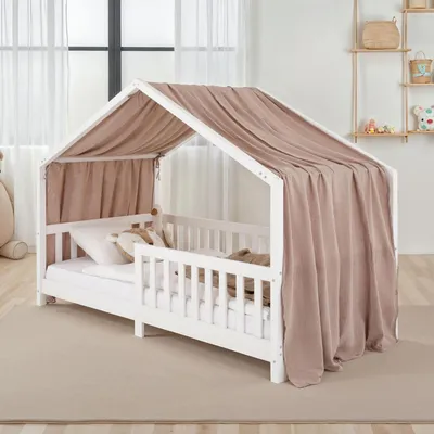 A child's house bed with a taupe canopy in a room.